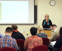 Dr. Boss in front of students teaching with projector in background
